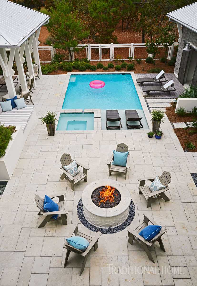  Even the fire pit manages to be nautically-inspired with the seaside chairs and blue cushions in this beautiful backyard. Via Traditional Home