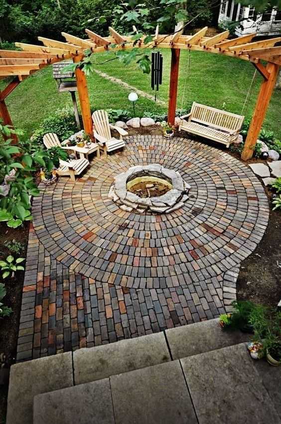 This fire pit forms the center of an intricate backyard design. Via Woohome